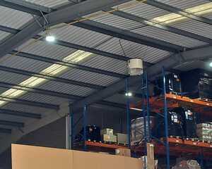 Interior of a warehouse with metal beams, shelves, and storage items.