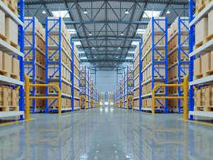 A construction worker in a hard hat and safety gear using a tablet indoors.
