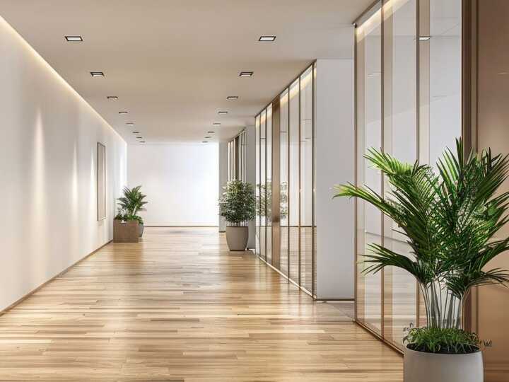 Modern hallway with wood flooring, glass walls, and potted plants.