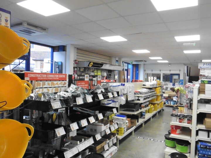 Clothing store interior with light-colored garments displayed on racks and mannequins.