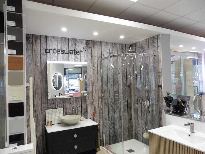 Modern bathroom with glass shower, stylish sinks, and wooden accent wall.