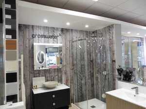 Modern bathroom with glass shower, stylish sinks, and wooden accent wall.